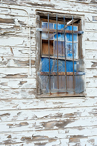 旧墙上的蓝窗白色木头玻璃剥皮铁棒背景图片
