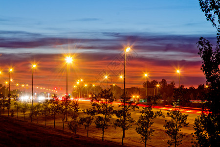 夜间1号公路天空树木过往路灯光线尾灯交通条纹头灯背景图片