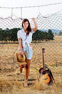 美丽的年轻乡村少女国家吉他帽子女孩草原情感农村场地稻草植被背景图片