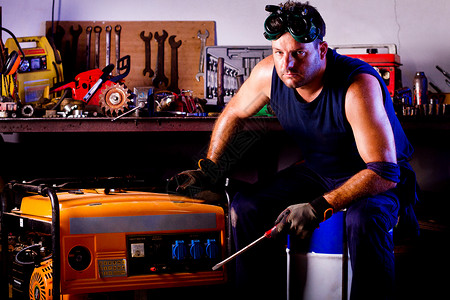电焊机男性机械技工工程师工作螺丝刀维修商业润滑脂肌肉男人车库风镜背景