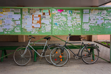 俄罗斯之旅海报两辆旧自行车在街上对一个公告板倾斜运输金属踏板控制板旅行民众木板车轮框架海报背景