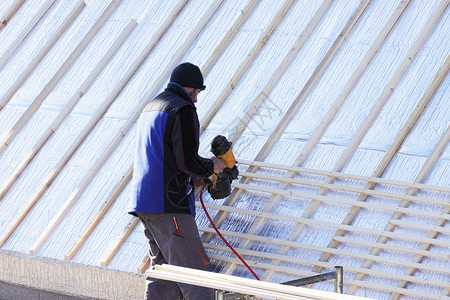 顶上的人屋顶在木柴新屋顶上工作木匠木工建设房子工人安全男性卵石屋主承包商背景