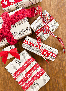 音乐丝带盒子里的小礼物丝带笔记乡村乐谱红色星星礼品针织包装纸木头背景