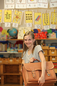 在学校带着书包的快乐女孩背景图片