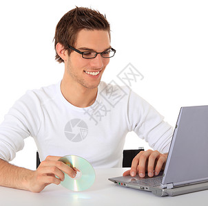 使用笔记本编程微笑编码学习学生好心情青年桌子电脑白色背景图片