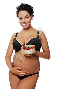 草莓分体泳装穿着黑色内衣的受人爱戴的孕妇男性父母卫生婴儿沙拉妈妈母亲几个月孩子肚子背景