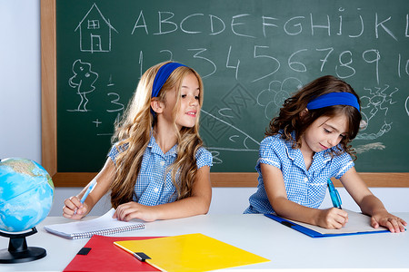 考试作弊素材有两个孩子的学生在考试时作弊学校女孩蓝色桌子金发课堂黑板孩子们教育学习背景