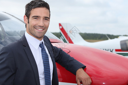 年轻的商务人士站在飞机前的一架飞机前面高清图片