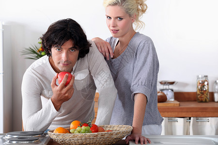 一对夫妇在厨房的厨房里 男人正在吃苹果高清图片