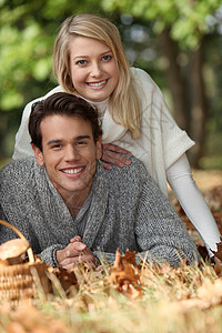 一对年轻夫妇躺在草地上 一个蘑菇篮在地上高清图片
