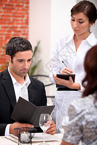 一男一女在餐厅订餐 服务员正在下订单的开单背景图片