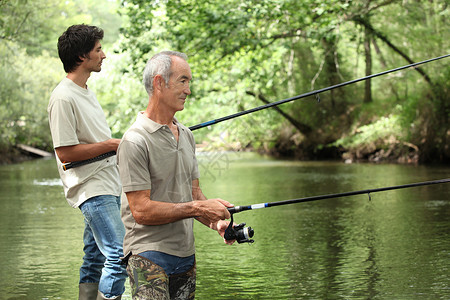 父亲和儿子捕鱼钓鱼靴子娱乐时间卷轴假期家庭男生空闲男人背景图片