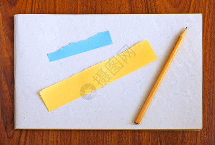 木制背景的空白笔记本和铅笔及撕扯纸背景