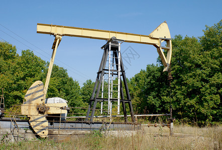 钻机黄色生产石油的机械火箭车背景