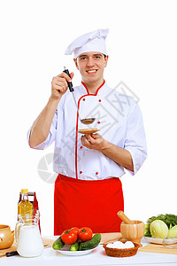 青年烹饪准备食品职业帽子勺子美食餐厅桌子酒店男人工作微笑背景图片