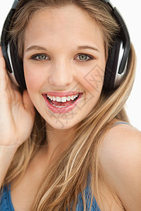 一个穿着耳机的美丽年轻金发美女的肖像背景图片