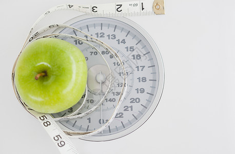 秤重量绿色苹果圆圈 带宽度和重量尺度保健水果饮食宏观营养测量乐器仪表厘米尺寸背景