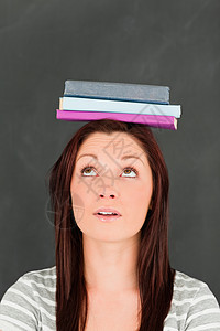 年轻女人看着她头上戴的书 看她的头部背景图片
