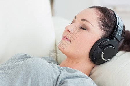 躺在沙发上听音乐的放轻松的女人高清图片