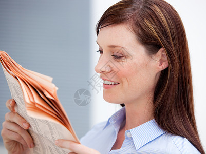 笑笑的女商务人士阅读报纸背景图片