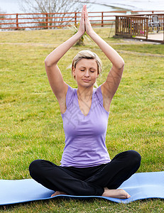 瑜伽导师坐在草地上做瑜伽的放松的女人背景