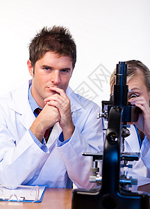 科学家们透过显微镜观察科学家外套治愈化学家药品实验女士学生电脑医生背景图片