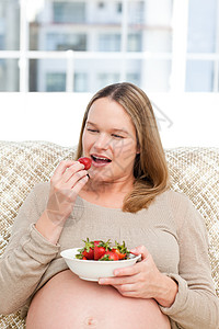 肚子饿的孕妇吃草莓 坐在活人中间背景