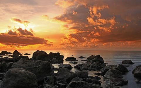 海湾日落风景波浪岩石海岸太阳反射橙子海岸线海滩天空高清图片