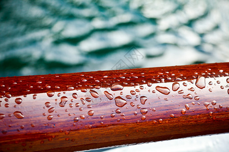 密封木头上的雨滴防风雨红木保护天气宏观水滴红色液体棕色粮食背景