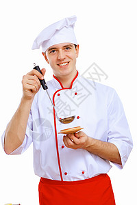 青年烹饪准备食品桌子生活勺子帽子男人职业餐厅美食蔬菜微笑背景图片