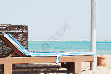 空沙滩椅 在海面上用遮晒草享受海滩闲暇天空躺椅海洋海岸旅游座位休息室背景图片
