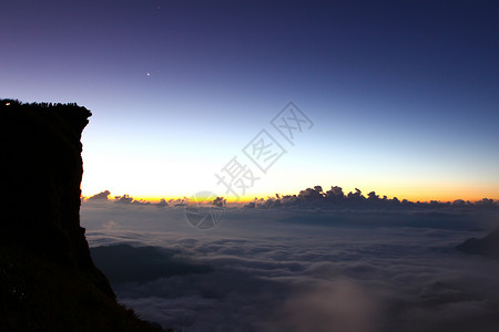 日出时 在千阿的出现高峰和云彩风景阳光薄雾顶峰岩石远足爬坡旅游日落横线地平线背景图片