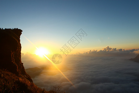 日出时 在千阿的出现高峰和云彩风景地平线爬坡阳光远足顶峰场景旅行环境天空日落背景图片