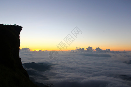 日出时 在千阿的出现高峰和云彩风景爬坡地平线远足薄雾日落蓝色阳光旅游天空地标背景图片