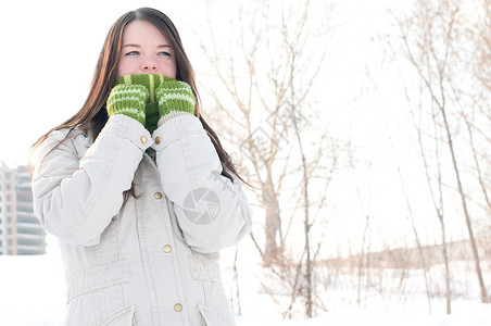 青绿美丽的女孩在冬天的风景中女士棉被手套长发青少年黑发女性外套微笑快乐背景图片