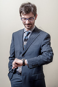 寻找手表的商务人士商业成人领导者领带时间夹克职业眼镜背景图片