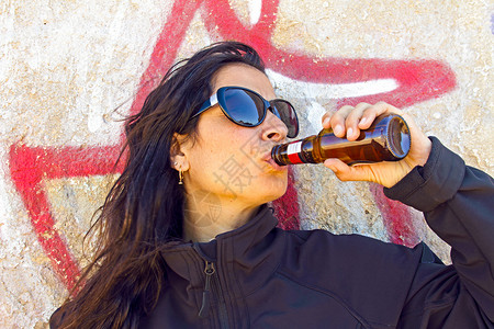 一听啤酒女人在涂鸦墙前喝啤酒背景