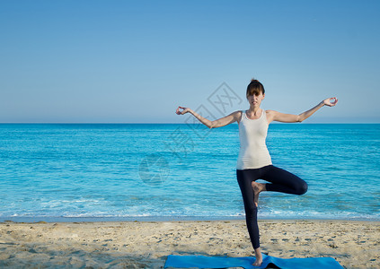 在海边练瑜伽的Yang女人身体成人冥想精神海浪海滩运动活力成功女孩背景图片