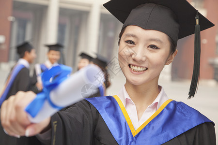 青年女毕业生毕业文凭女性摄影年轻人大学大学生教育礼服成功头肩手臂图片