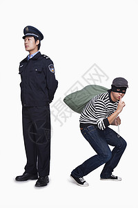 中国法制宣传日警察和小偷勇气警官帽子年轻人作曲逮捕制服隐藏摄影黑发背景