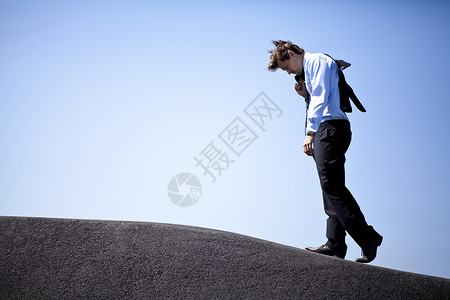 没精打采的商务人士攀登山丘背景