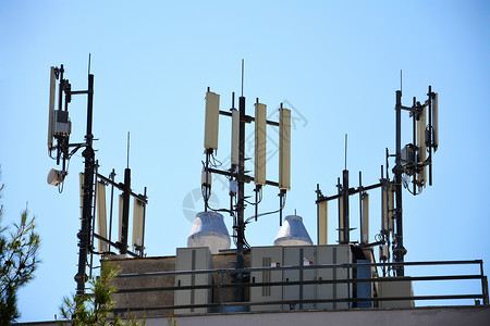 信号发送建筑物屋顶上的大天线数据水平金属信号播送住宅电话收音机编程卫星背景