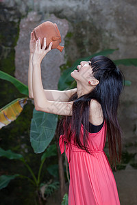 红色小彩旗亚裔女孩饮用粘土锅背景