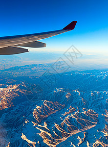 开启旅游模式乘飞机飞越山上背景