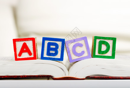 书上有 ABCD 字母块玩具老师拼写学习家庭积木乐趣幼儿园木头知识背景图片