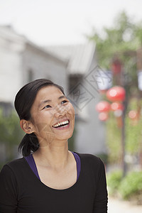 年轻女子笑着看远去省会服装乐趣黑发城市幸福摄影休闲享受长发背景