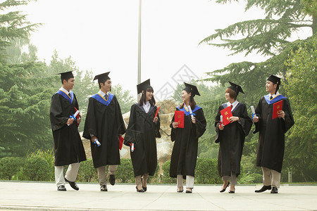 拥有相互看对方文凭的大学毕业生青年小组青年组;学生人数和毕业证书保持高清图片素材