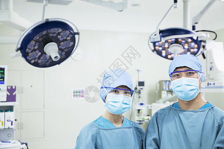 两名外科医生在手术室佩戴外科口罩 直视照相机的肖像高清图片