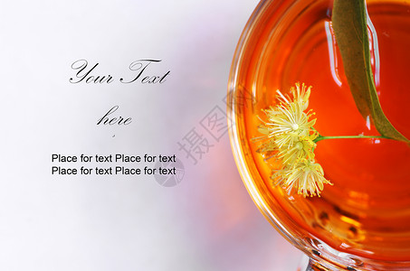 透明硬纱林肯茶在一个透明的杯子里 还有明亮的花朵背景