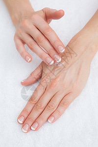 手头上涂奶油的女人手指甲手指润肤护理指甲皮肤按摩指甲油美容治疗背景图片